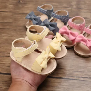 Detail view of soft-sole baby girl summer sandals with cute bows and polka dot patterns