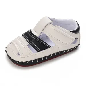 Vue détaillée de sandales pour bébé blanches et noires avec semelles antidérapantes