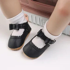 Close-up of black infant Mary Jane shoes with decorative bow and soft sole for baby girls