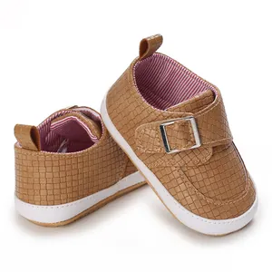 Nahaufnahme brauner Baby-Lauflernschuhe mit weicher weißer Sohle und Schnallenriemen