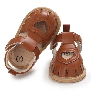 Détail de sandales marron pour bébé avec découpe en cœur et des semelles souples