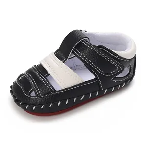 Vue détaillée de sandales pour bébé en cuir noir et blanc avec semelle en caoutchouc