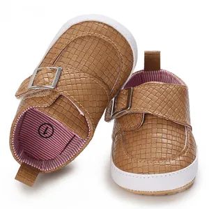 Detailansicht von braun gewebten Baby-Lauflernschuhen mit weichen weißen Sohlen