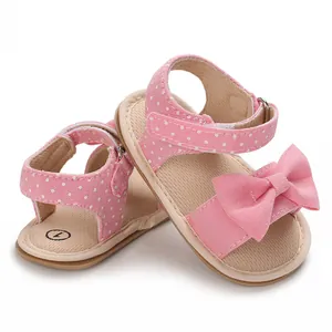 Macro view of pink baby sandals featuring white polka dots and a decorative bow detail