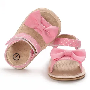 Detail of pink baby girls' bow sandals with polka dot straps and soft non-slip sole