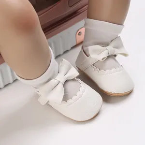 Detail view of white baby princess shoes with bow and lychee texture for infant walking