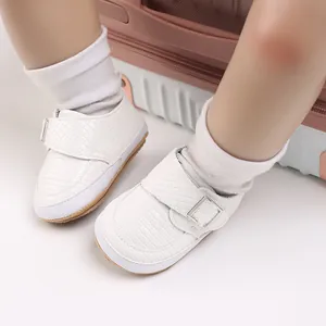 Nahaufnahme von weißen, gewebten Baby-Lauflernschuhen mit weicher Sohle und Schnalle