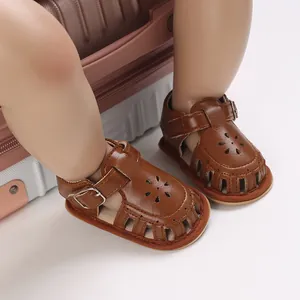 Detailansicht brauner Baby-Sandalen aus Leder mit Blumenausschnitten und Schnalle