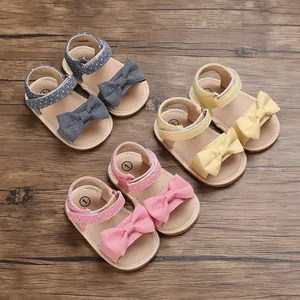 Detail view of pink yellow and blue baby girl summer sandals with bows and soft soles