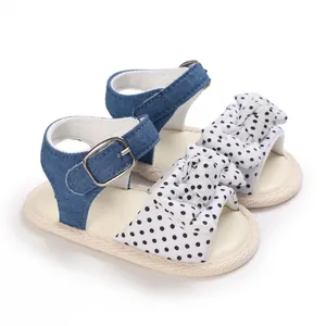 Dettaglio di sandali per neonata con fiocco a pois e cinturino in denim estivo