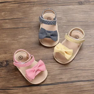 Close-up of infant girls' summer sandals with soft soles and decorative bow knots