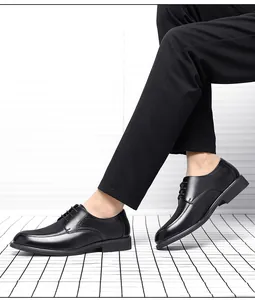 Detailed view of men's black business casual leather shoes worn with black trousers