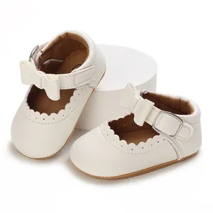 Detailed view of white baby princess walking shoes with bow and scalloped trim