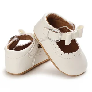 Close-up view of white infant princess shoes featuring a delicate bow and buckle strap.