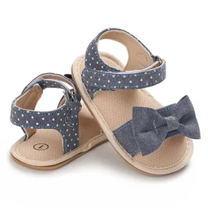 Close-up detail of blue polka dot bow sandals for baby girls featuring soft walking soles