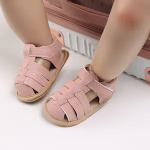 Close-up of pink soft-soled baby sandals featuring a woven design and velcro strap