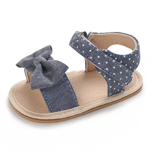 Close-up detail of baby girl's blue polka dot sandal with soft sole and bow accent