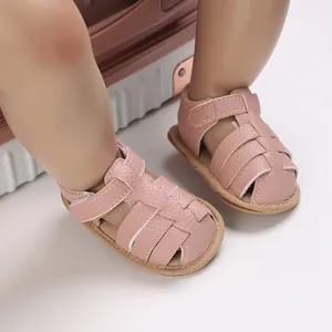 Detailed view of pink soft-soled leather sandals for baby boys and girls ages 0-1.