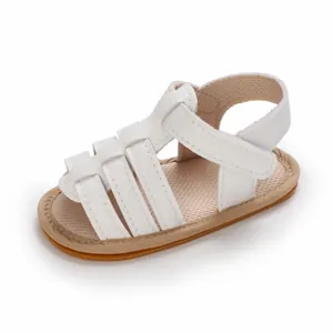 Nahaufnahme von weißen Baby-Sommer-Sandalen mit rutschfesten Gummisohlen und Klettverschluss.
