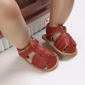 Detailed close-up view of red faux leather soft sole baby sandals with woven strap design