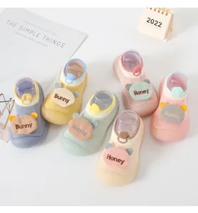 Detail view showing a collection of colorful cartoon baby sock shoes for newborn toddlers.
