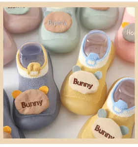 Detailed macro view of soft baby sock shoes featuring cute 3D bunny ear patches.