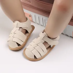 Close-up of beige soft sole baby sandals with woven texture and Velcro strap