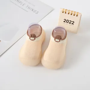 Detailed view of breathable beige baby sock shoes with flexible anti-slip rubber soles.