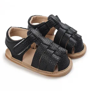 Detailed macro view of black soft-sole baby sandals with adjustable velcro strap
