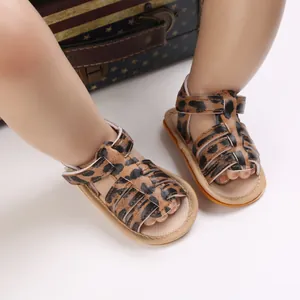 Nahaufnahme von Baby-Sandalen mit Leopardenmuster und rutschfester Gummisohle für Neugeborene.