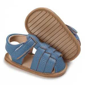 Detail view of blue soft-soled baby sandals with anti-slip brown textured rubber base.