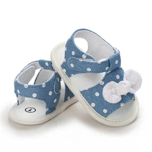 Detailed view of blue polka dot baby girl sandals featuring a charming white bow decoration