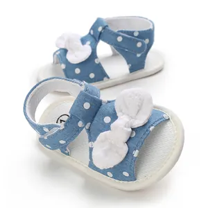 Detailed view of blue polka dot baby girl sandals with white bow and soft sole