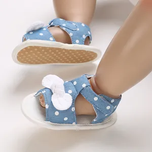 Detail view of blue polka dot baby girl summer sandals with white bow decoration