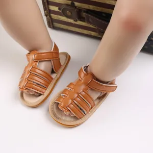 Detailed view of brown infant sandals with non-slip soles and Velcro straps