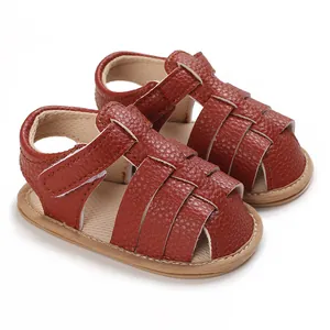 Close-up of brown textured leather baby sandals with soft soles and velcro strap
