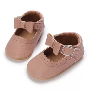 Detail view of pink soft sole baby pre-walker shoes with bow and scalloped edges