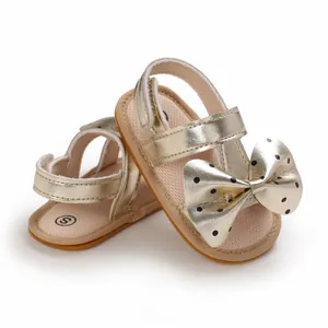 Sandalias doradas para bebé niña con lazo de lunares y suela blanda
