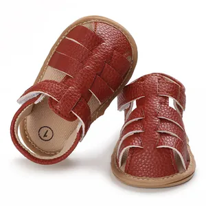 Detailed macro view of brown faux leather baby sandals with soft soles and woven straps