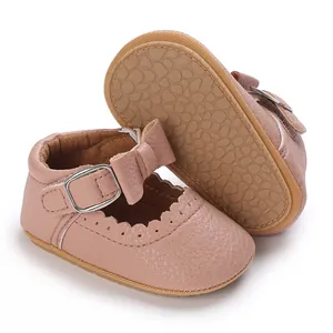Close-up of pink baby pre-walker shoes with bow detail and soft pebble-textured sole