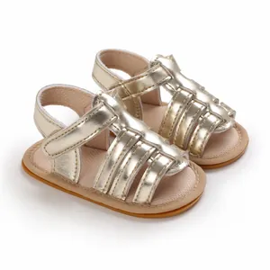 Close-up of metallic gold infant sandals with non-slip rubber soles for first steps