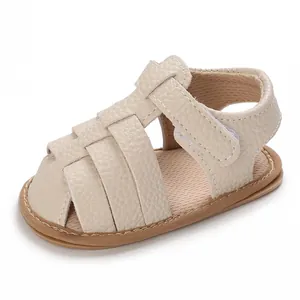 Close-up view of a cream textured leather baby sandal featuring a secure hook-and-loop strap