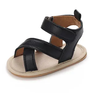 Gros plan de sandales de marche noires pour bébé avec semelle souple et fermeture velcro