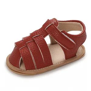 Close-up of red soft-sole baby sandals with cross-strap design for summer infant wear.