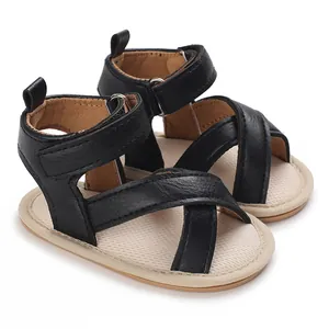 Détail de sandales d'été pour bébé noires avec semelle souple et brides croisées.