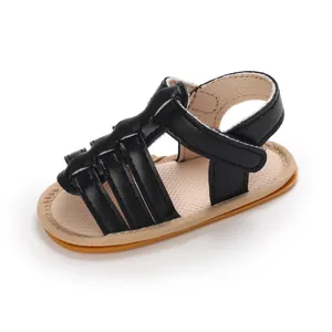 Macro detail of black leather baby first-walker sandals with a non-slip rubber sole