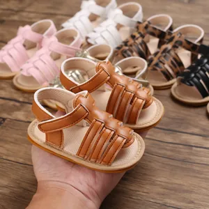 Detailed view of tan baby walking sandals with woven straps and soft non-slip rubber sole.