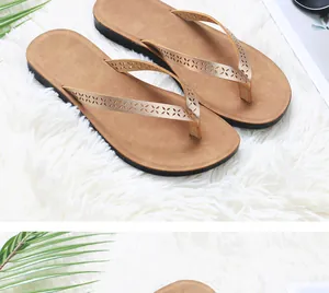 Women's PU leather flip-flops with laser-cut floral straps on white rug.