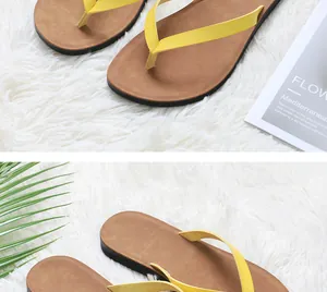 Detailed macro view of yellow straps and brown soles of women's flip-flops