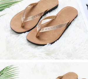 Detail view of stylish brown flip-flops featuring intricate floral laser-cut pattern straps